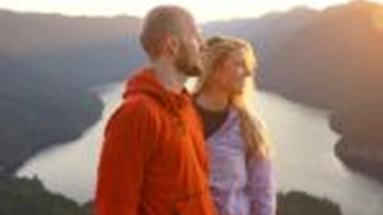 Close up on a plate of mashed potatoes, topped with baked pork chops with cream of mushroom soup, and a side of green beans.